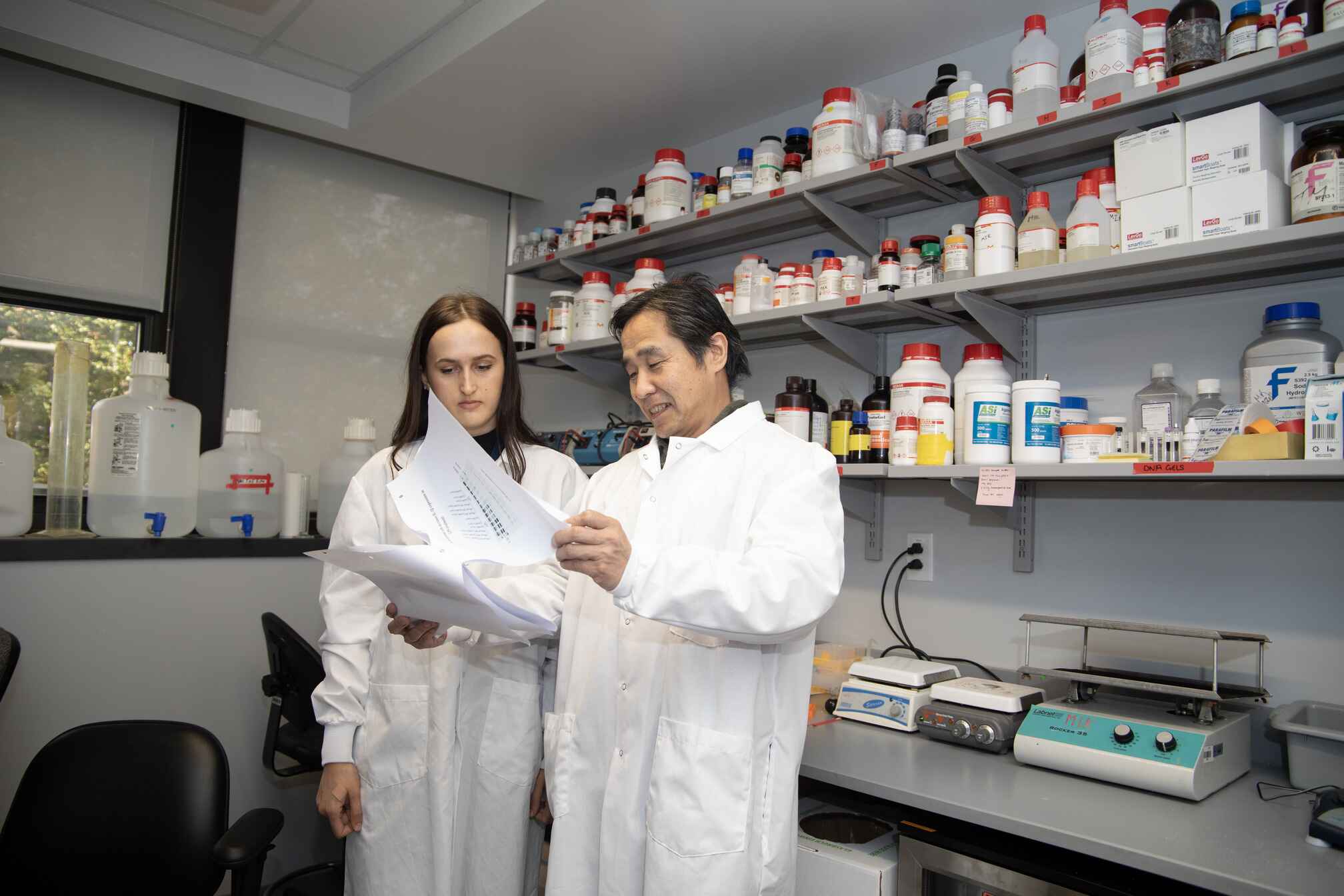 A man and woman in lab coats conducting experiments in a laboratory.