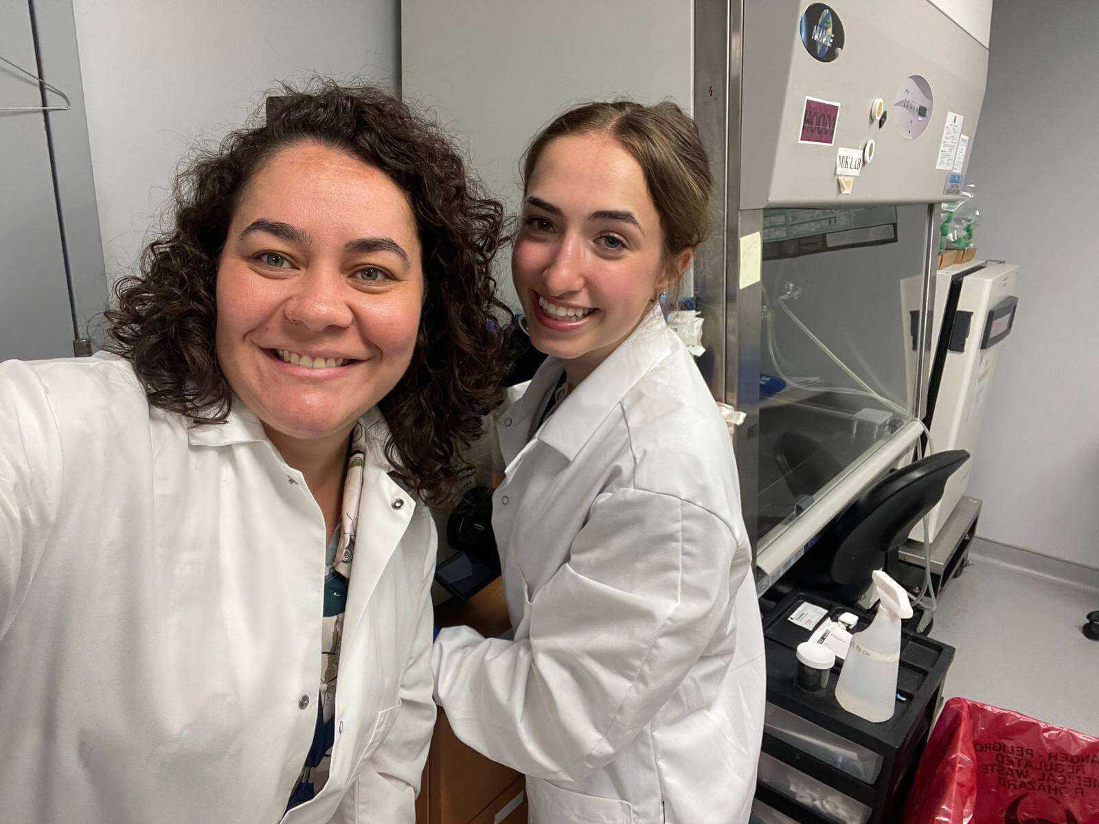 Scientists pose in front of a microscope