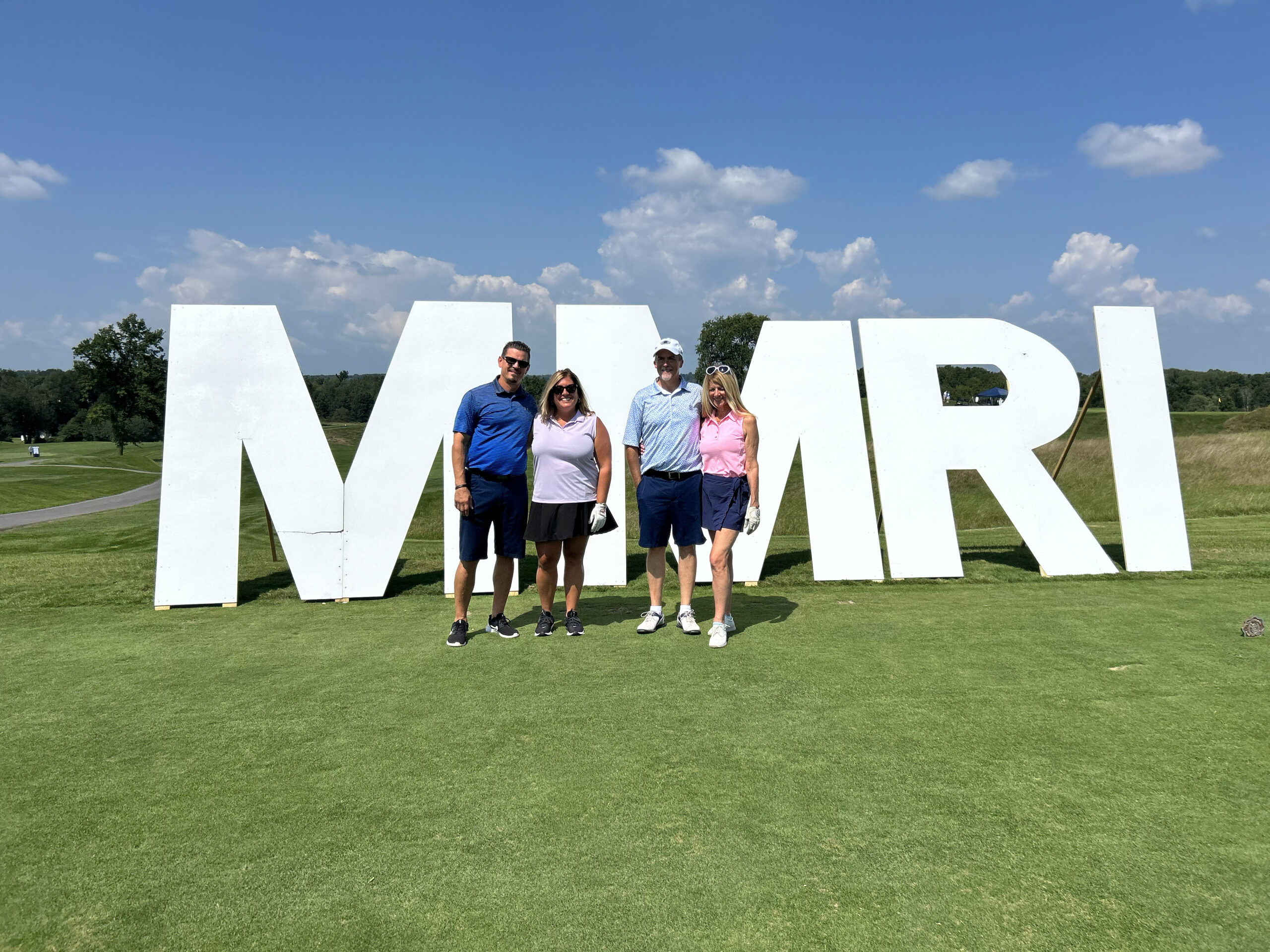 Golfers in front of MMRI sign